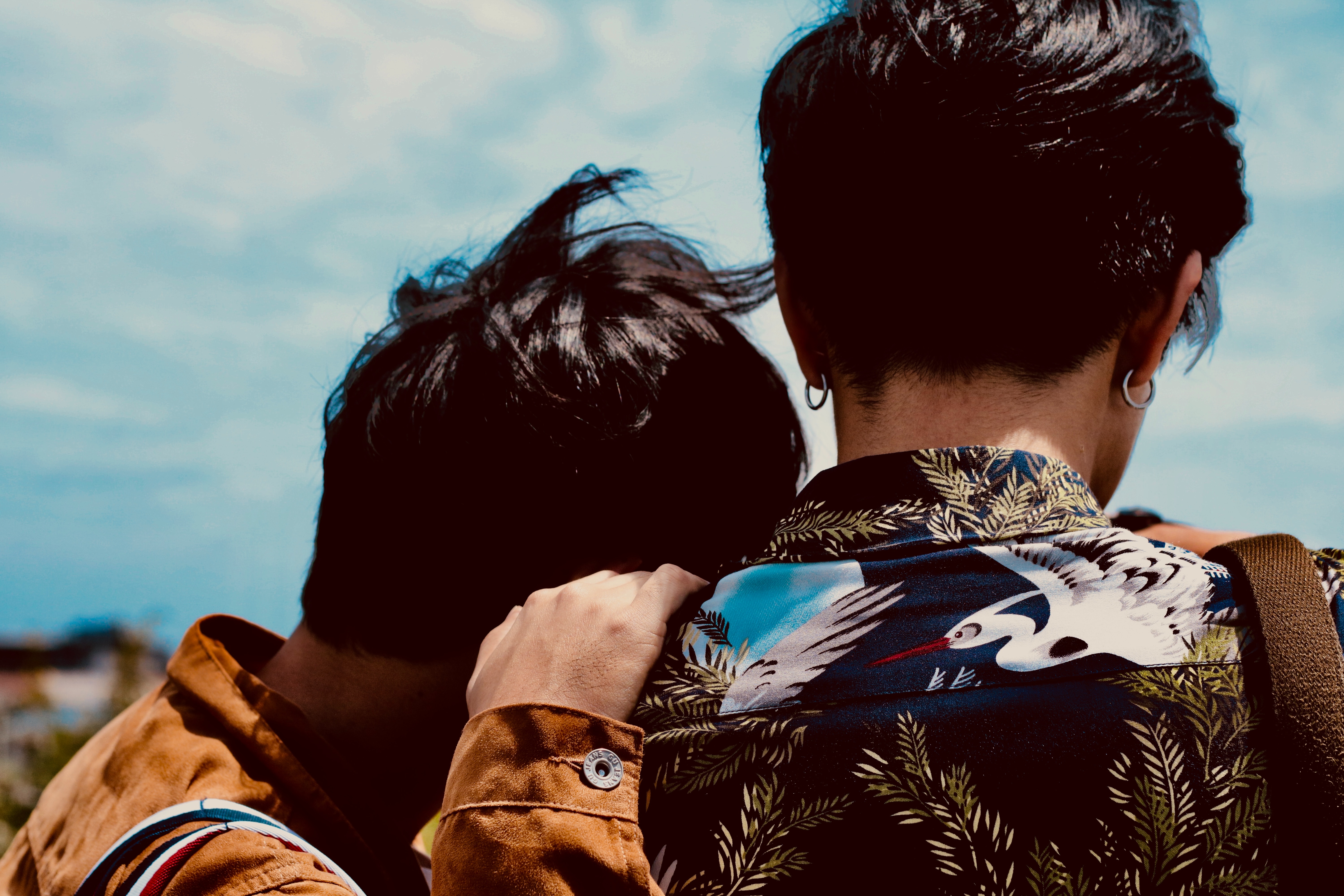 man leaning on other man's shoulder